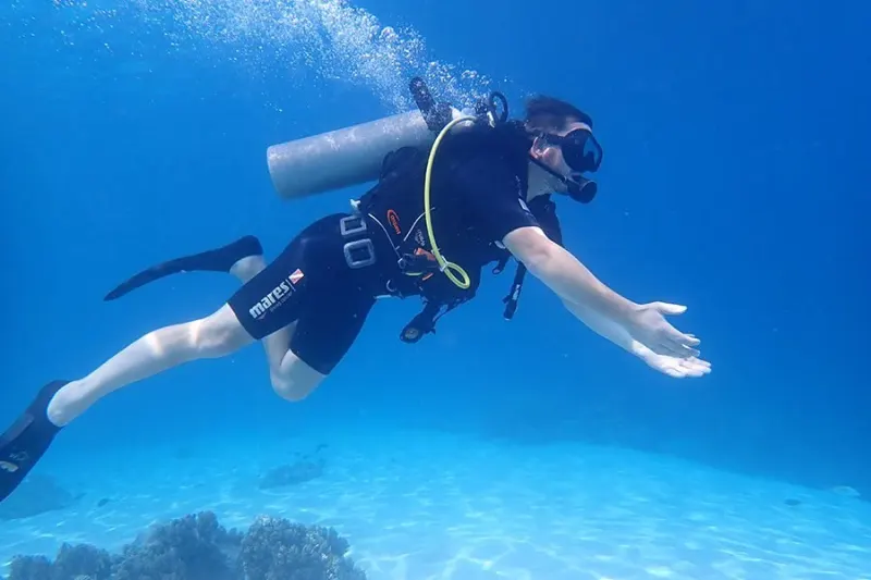 Beginner trying scuba diving with an instructor at Menjangan